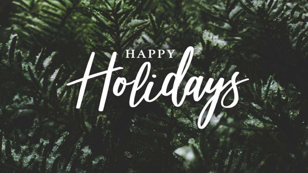 Happy Holidays graphic set against greenery