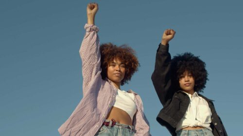 Black women holding their fists up in protest