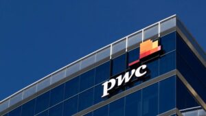 A PwC logo against the backdrop of a glass building